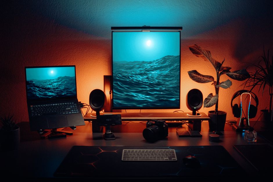 Stylish office setup featuring dual monitors, tech gadgets, and ambient lighting